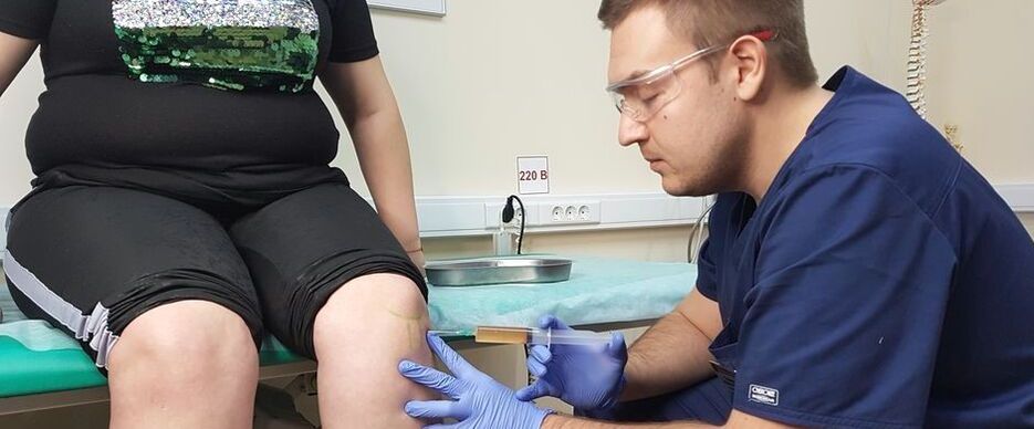 Orthopedic surgeon performs intra-articular injection into knee joint to treat osteoarthritis